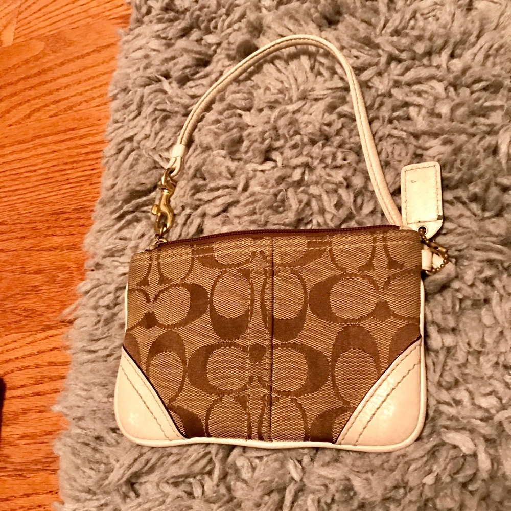 brown logo and white leather Coach wristlet